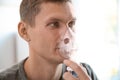 Young man using asthma machine indoors Royalty Free Stock Photo