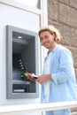 Young man using cash machine for money withdrawal Royalty Free Stock Photo