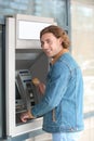 Young man using cash machine for money withdrawal Royalty Free Stock Photo