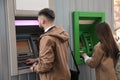 Young man using cash machine for money withdrawal outdoors Royalty Free Stock Photo