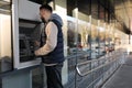 Young man using cash machine for money withdrawal outdoors Royalty Free Stock Photo