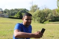 Young man using cellphone outdoor in park Royalty Free Stock Photo