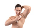 Young man using deodorant on white background Royalty Free Stock Photo