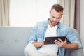 Young man using digital tablet on sofa Royalty Free Stock Photo
