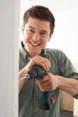 Young Man Using Electric Drill In House Renovation Project