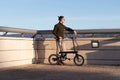 Young man using a folding electric bicycle to move in the city where he lives and be greener with the environment