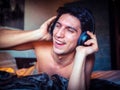 Young Man Using Headphones Lying Alone On His Bed Royalty Free Stock Photo