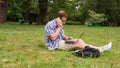 Young man using his laptop on the grass. Royalty Free Stock Photo