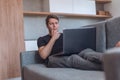 Young man using his laptop lying on the sofa in the living room Royalty Free Stock Photo