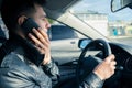 Young man using his phone while driving the car. Dangerous driving Royalty Free Stock Photo