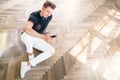 Young man using his smartphone with headphones, listen the music and sit on the floor Royalty Free Stock Photo