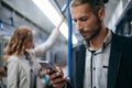 Young man using his smartphone on a subway train. Royalty Free Stock Photo