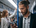 young man using his smartphone on a subway train. Royalty Free Stock Photo