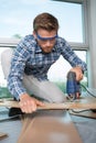 Young man using jigsaw on laminate flooring Royalty Free Stock Photo