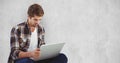 Young man using laptop against wall Royalty Free Stock Photo
