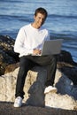 Young man using laptop at beach Royalty Free Stock Photo