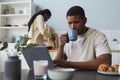 Young man using laptop during breakfast Royalty Free Stock Photo