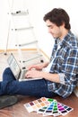 Young man using laptop while choosing color of his flat Royalty Free Stock Photo