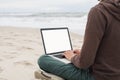 Young man using laptop computer on a beach, white blank, empty screen monitor, Freelance work, technology, distance education Royalty Free Stock Photo