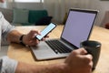Young man using laptop computer and smartphone Royalty Free Stock Photo