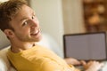 Young man using laptop on his couch Royalty Free Stock Photo