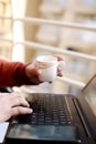 Young man is using laptop with holding tea cup in hand Royalty Free Stock Photo