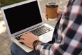 Young man using laptop outdoors. Space for text Royalty Free Stock Photo