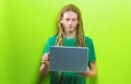 Young man using a laptop on a solid background