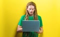 Young man using a laptop on a solid background