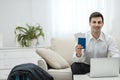 Young man using laptop to book airplane tickets or do online check-in at home. Royalty Free Stock Photo