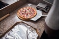 Young man using metal pizza peel in pizzeria Royalty Free Stock Photo