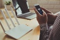 closeup of a wifi router and a man using smartphone on living room at home ofiice Royalty Free Stock Photo