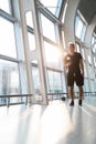 Young man using mobile phone app in airport. Young man texting smartphone walking inside office building or airport terminal Royalty Free Stock Photo