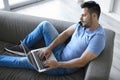 Young man using mobile phone and laptop Royalty Free Stock Photo