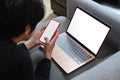 Man using mobile phone and laptop while lying on couch. Royalty Free Stock Photo