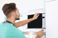 Young man using modern microwave oven Royalty Free Stock Photo