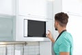 Young man using modern microwave oven Royalty Free Stock Photo