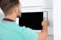 Young man using modern microwave oven Royalty Free Stock Photo