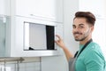 Young man using modern microwave oven Royalty Free Stock Photo