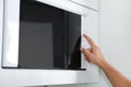 Young man using modern microwave oven Royalty Free Stock Photo