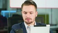 Young Man Using a Phone and a Tablet in the Office Royalty Free Stock Photo