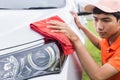 Young man using red microfiber cloth cleaning body of new silver Royalty Free Stock Photo