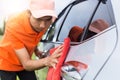 Young man using red microfiber cloth cleaning body of new silver Royalty Free Stock Photo