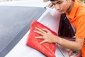 Young man using red microfiber cloth cleaning body of new silver Royalty Free Stock Photo