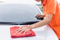 Young man using red microfiber cloth cleaning body of new silver Royalty Free Stock Photo