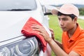 Young man using red microfiber cloth cleaning body of new silver Royalty Free Stock Photo