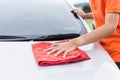 Young man using red microfiber cloth cleaning body of new silver Royalty Free Stock Photo