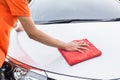 Young man using red microfiber cloth cleaning body of new silver Royalty Free Stock Photo