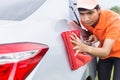 Young man using red microfiber cloth cleaning body of new silver Royalty Free Stock Photo