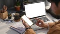 Young man using smart phone and working with computer laptop at modern home office. Royalty Free Stock Photo